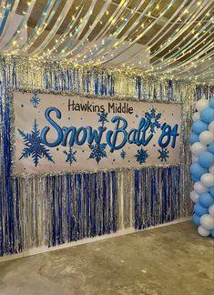 balloons and streamers decorate the backdrop for a snow ball party