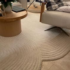 a living room with a couch, coffee table and rugs on the floor in front of it