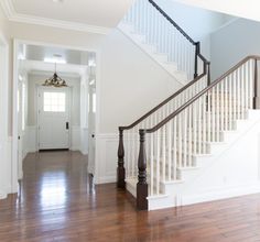 an empty entryway with stairs and hard wood flooring