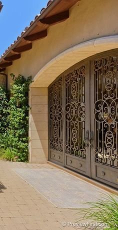 a house with an iron gate and brick walkway