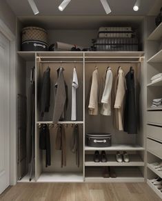 an organized closet with clothes, shoes and other items on shelves in the center of the room