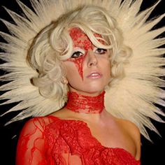 a woman with white hair and red makeup is dressed up in an elaborate wig, headdress and veil