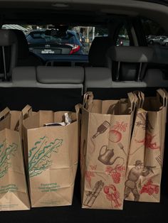 several brown paper bags sitting in the back of a car with drawings on them,