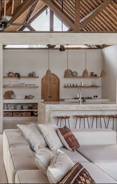 a living room filled with furniture next to a kitchen