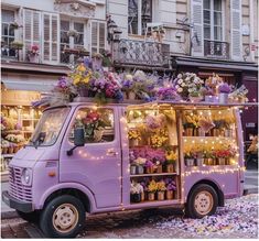 an ice cream truck decorated with flowers and fairy lights on the street in paris, france