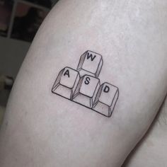 a person with a tattoo on their arm has a computer keyboard and letters that spell out words