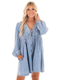 Unleash your inner denim diva with our Blue Jean Beauty Denim Romper! This playful romper features a pleated front with a trendy tie detail, along with convenient pockets for all your essentials. And with a deep v-neckline, you'll be turning heads wherever you go. Time to rock that denim look in style! Dark Wash Denim V-neck Dress With Pockets, Trendy V-neck Denim Jumpsuit For Spring, Spring Cotton V-neck Denim Jumpsuit, Chic Denim V-neck Dress With Pockets, V-neck Denim Dress With Pockets For Day Out, Chic V-neck Denim Dress With Pockets, Light Wash V-neck Denim Dress, V-neck Denim Blue Dress For Day Out, Cotton Denim V-neck Jumpsuit