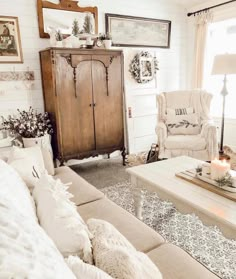 a living room filled with furniture and a wooden cabinet next to a fire place in front of a window