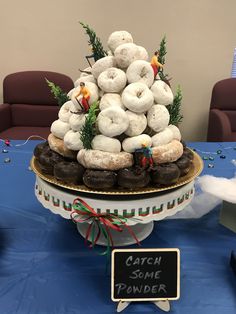 a table topped with donuts covered in frosting and sprinkles next to a sign that says catch some powder