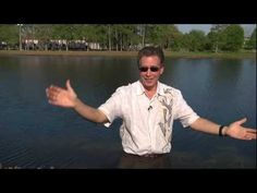 a man standing in front of a body of water with his hands out and smiling