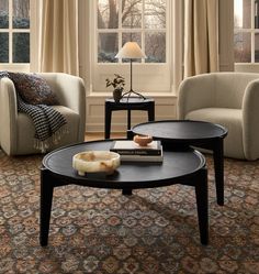 a living room with two couches and a coffee table in front of a window