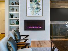 a living room with a couch, chair and fire place in front of the fireplace