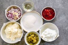 six bowls filled with different types of food on top of a cement floor next to each other