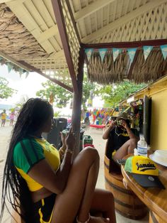 a woman sitting on top of a wooden barrel next to a tv screen in a bar