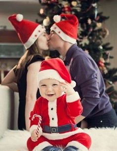 a baby sitting on the floor wearing a santa hat