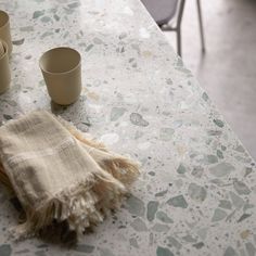 a table with two cups and a towel on it, next to some empty glasses