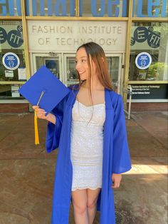 a woman in a white dress and blue graduation cap