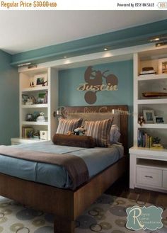 a bed room with a neatly made bed and bookshelves on the wall behind it