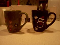 two coffee mugs sitting on top of a counter