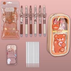 an assortment of pens, pencils and other items in a case on a pink background