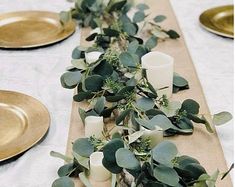 the table is set with candles and greenery