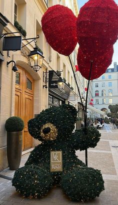 a teddy bear with two heart shaped balloons attached to it