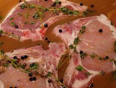 raw pork chops with herbs and spices in a bowl