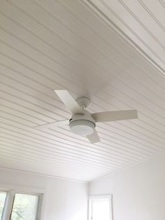 a ceiling fan in a room with white walls