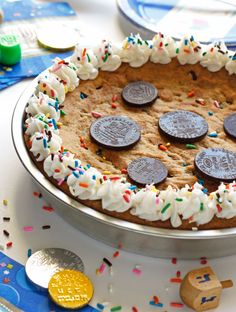 a cake with oreo cookies and sprinkles on it sitting on a table