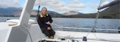 a man sitting on the bow of a sailboat