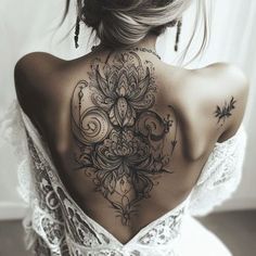 the back of a woman's shoulder with tattoos on her upper and lower back