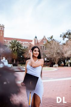 a woman in a white dress is posing for the camera with her hand on her head