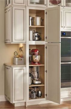 an open cabinet in a kitchen filled with appliances