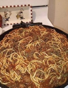 a large pizza covered in lots of spaghetti