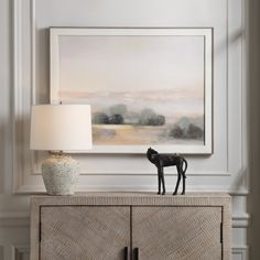 a black horse figurine sitting on top of a dresser next to a lamp