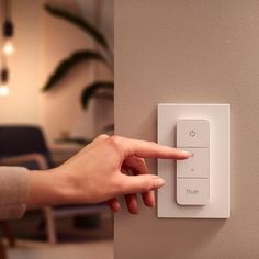 a person pressing the button on a light switch