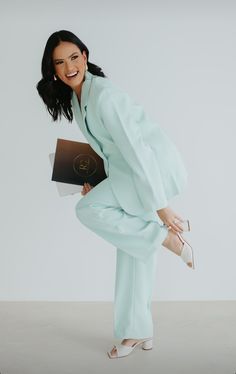 a woman is posing with her legs spread out and holding a book in one hand