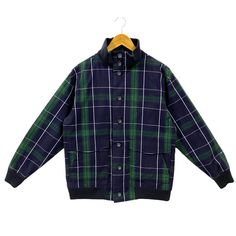 "Vintage Woolrich Plaid Bomber Jacket Oxford Cotton Checkered Bomber Casual Classic Mod Style Button Up Jacket Blue Green Medium * Used. In good condition (7/10) minor signs of wear, some light marks/spots and some yellowish dots on the lining. All good no defects (view photos) * Tagged size M. Flat laid measurements in inches (appox) - Chest (underarm to underarm) : 22.75\" - Length (side of neck seam to bottom hem) : 26.5\" - Shoulder (seam to seam) : 19\" - Sleeve (shoulder seam to cuff end) Plaid Outerwear With Button Cuffs For Work, Preppy Button-up Fall Outerwear, Fall Preppy Button-up Outerwear, Plaid Winter Outerwear With Button Cuffs, Retro Plaid Outerwear With Button Closure, Casual Plaid Blazer With Buttons, Retro Plaid Button-up Outerwear, Streetwear Sweater, Vintage Woolrich