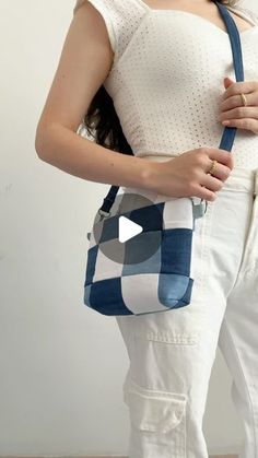 a woman holding a blue and white purse