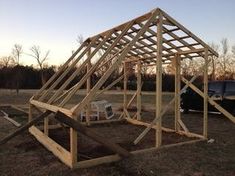 a car is parked in front of a wooden structure that has been built into the ground