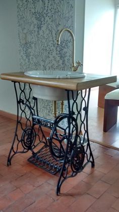 an old sewing machine turned into a sink in the middle of a room with tile flooring