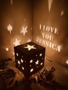 an illuminated box with stars on it and the words i love you, dessica projected behind it