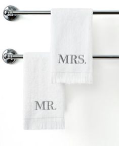 two white towels hanging on a towel rack with the word mr and mrs printed on them