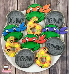 some decorated cookies are on a plate with the words dyshanan and two ninja turtles