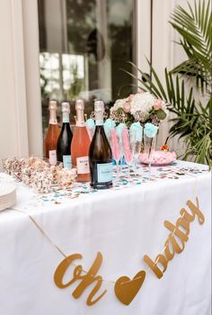 a table topped with lots of bottles of wine and confetti on top of it