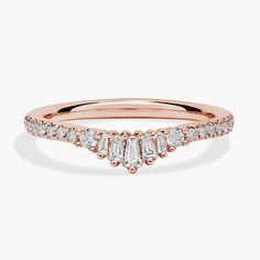 a rose gold ring with three baguets on the side and two diamonds in the middle