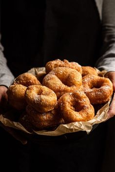 a person holding a plate full of doughnuts