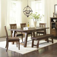 a dining room table with chairs and a bench