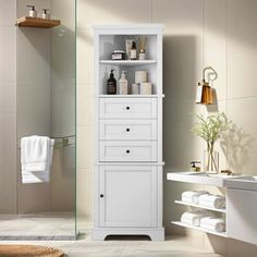 a white cabinet in a bathroom next to a sink and shower with towels on the shelves