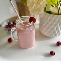 a pink smoothie in a mason jar with a straw sticking out of the top